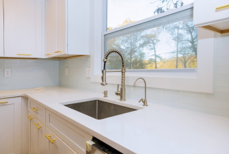 A modern white kitchen that show the differences between kitchen countertops vs cabinets.